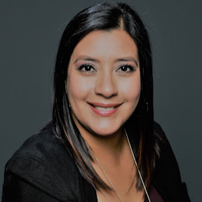 A headshot of Erika Jaquez smiling with a gray background.