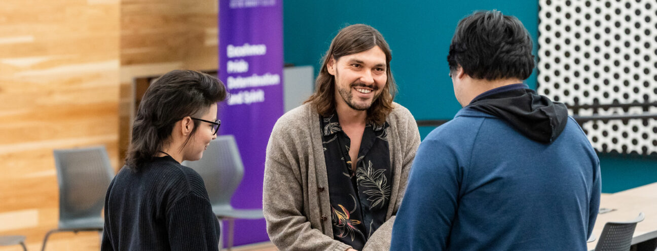 Three colleagues discussing a project in a modern, sunlit lab.